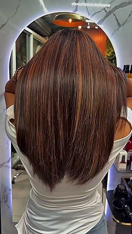 Cabello lacio castaño con luces canela y caramelo, frente al espejo en arco iluminado