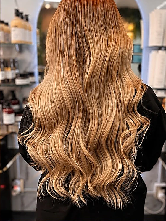 Después: el mismo cabello en rubio caramelo con ondas, brillo y luces