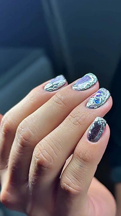 Uñas cortas de hombre con efecto cromo plateado y detalles de color