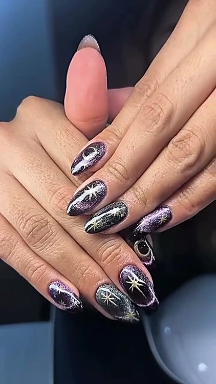 Uñas almendradas oscuras con efecto ojo de gato y estrellas plateadas