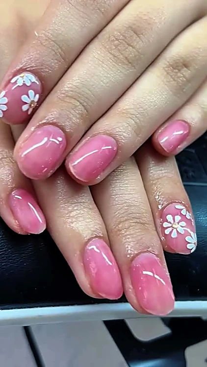 Uñas cortas en gelish rosa con flores blancas pintadas a mano